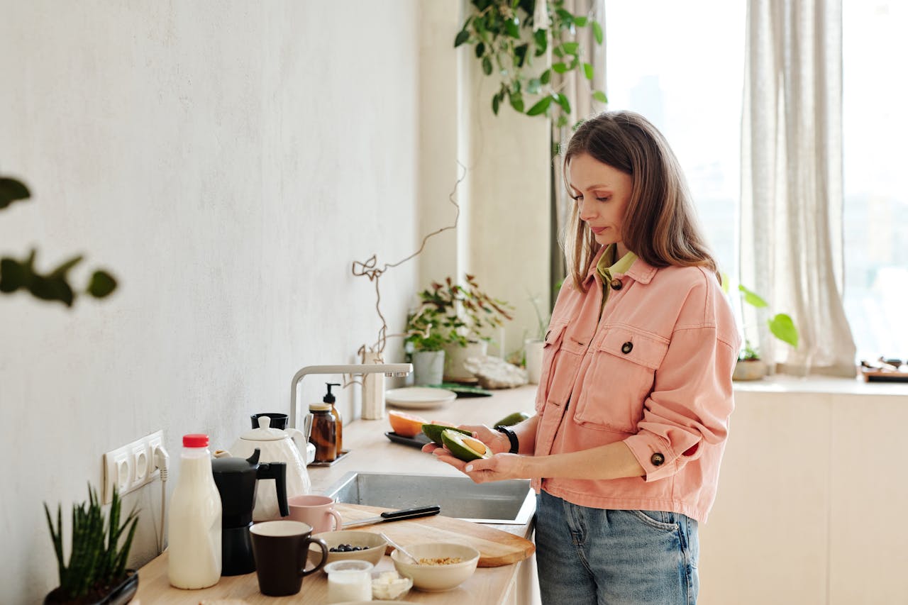 Woman looking at an avocado pit that would break a food waste disposal