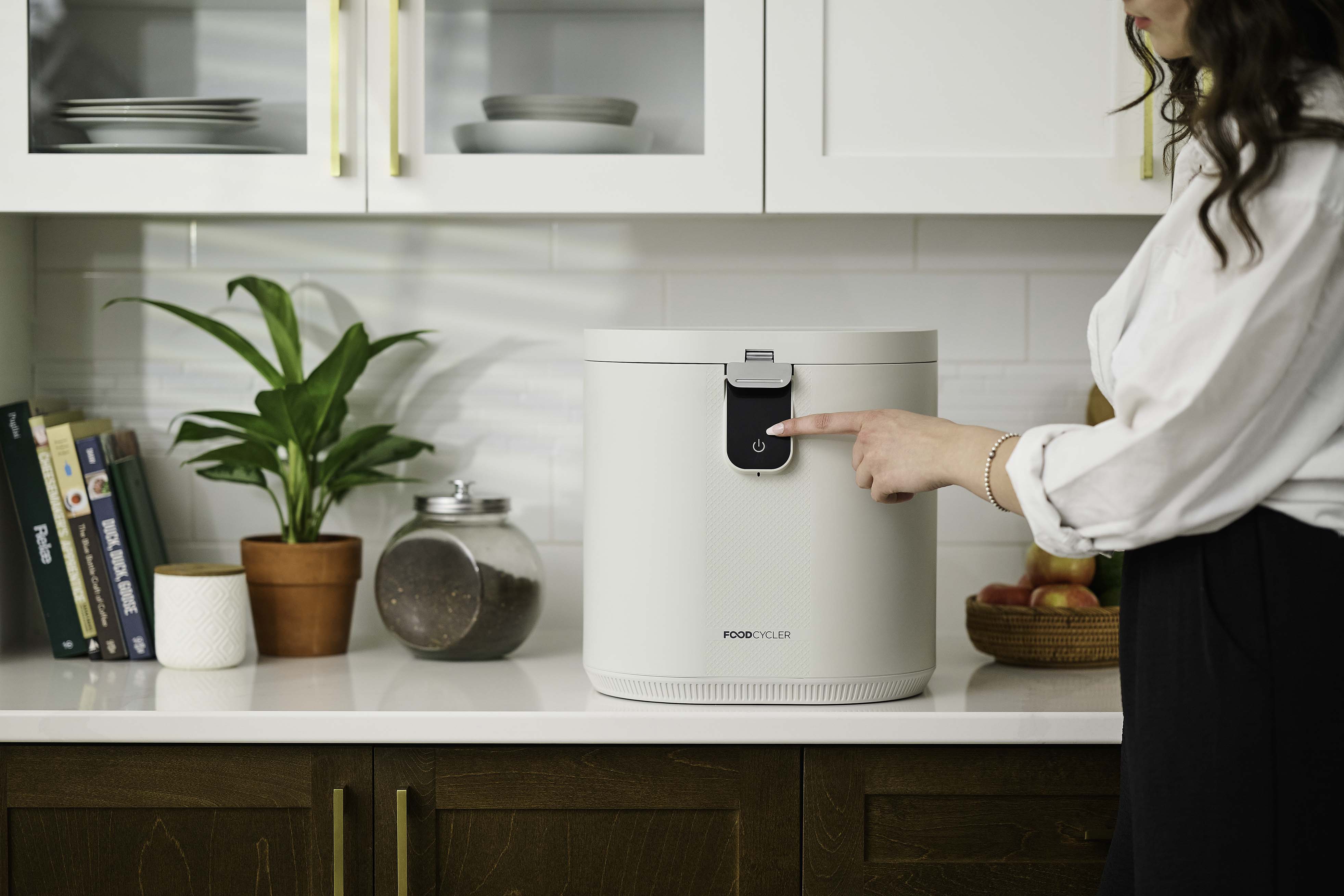 Person pressing the start button of the FoodCycler Eco 5.