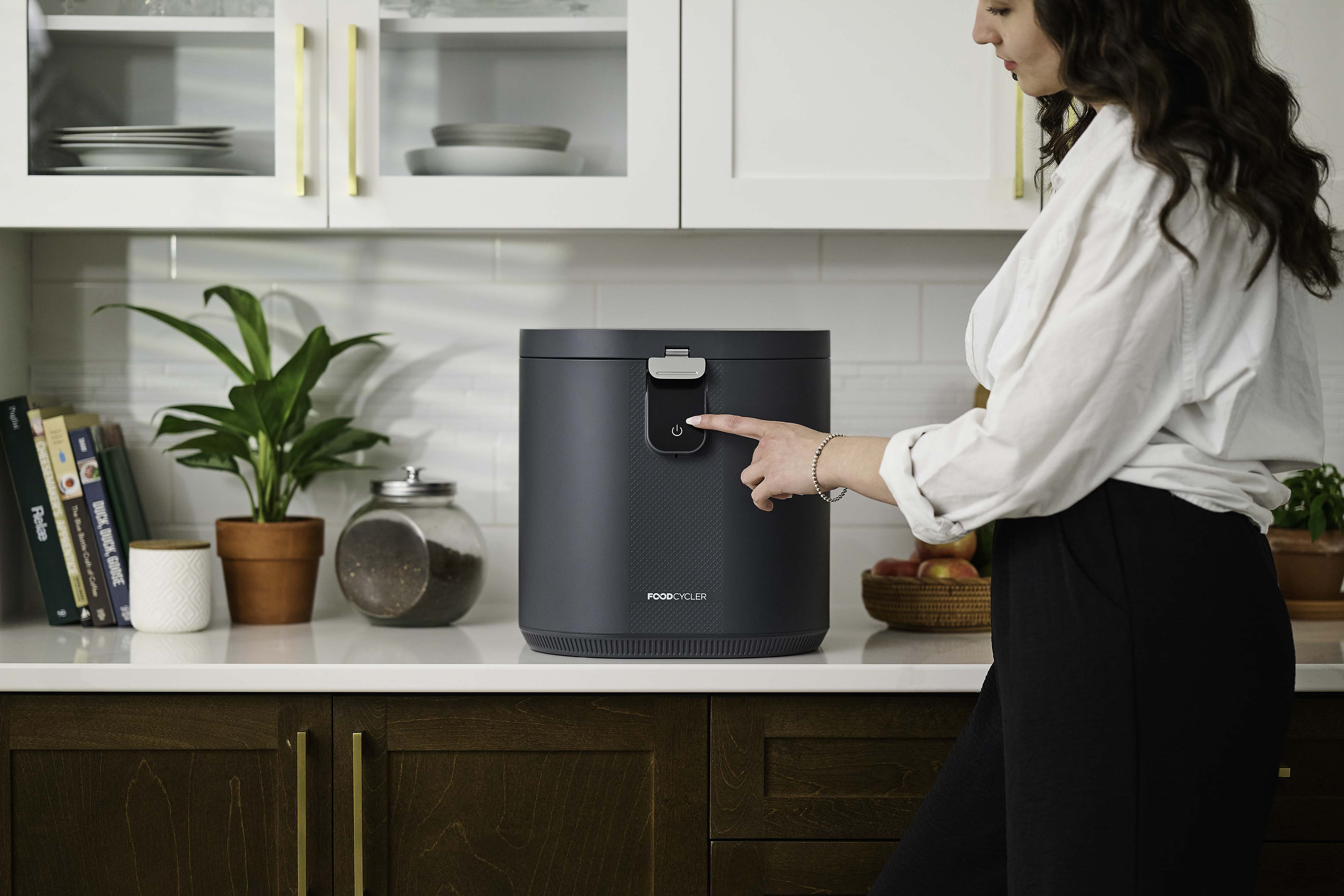 Mother and daughter putting food scraps into their Eco 5; kitchen setting