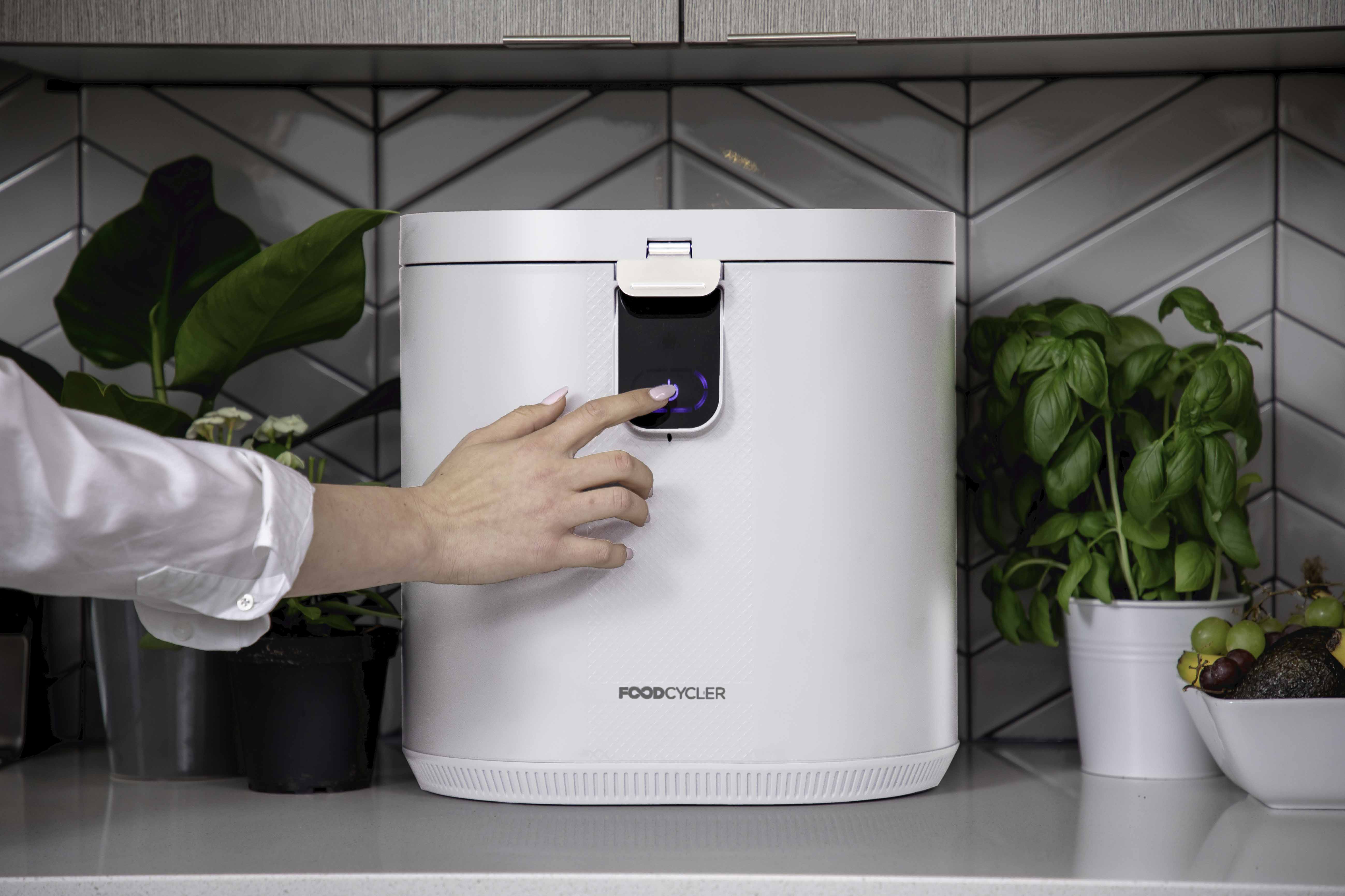 FoodCycler Eco 5 - White | Person pressing the on button