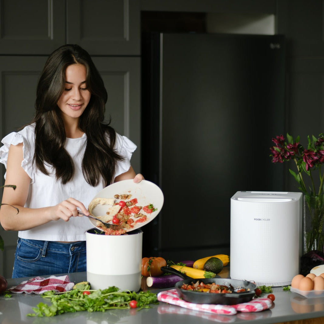 Person putting food scraps into their White FoodCycler Eco 3 bucket