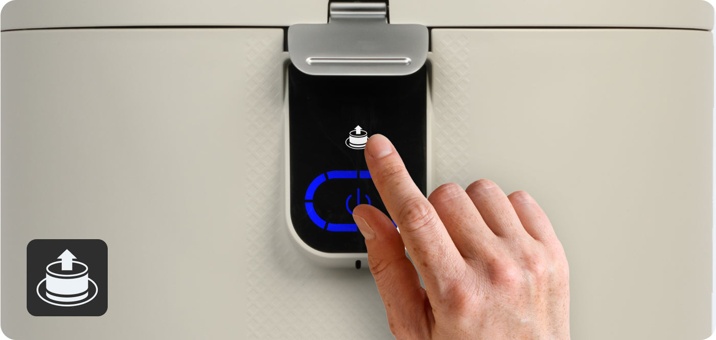 A hand pressing the white filter light button located above the power button on the front of a FoodCycler Eco 5