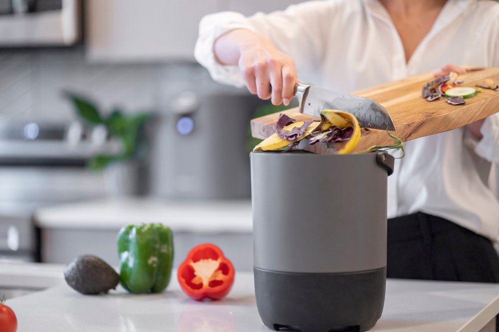 Person putting their food scraps into their FoodCycler bucket